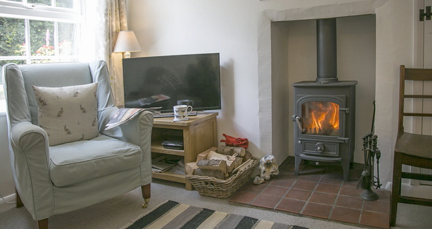 Cosy sitting room at Evas cottage with wood stove and tv